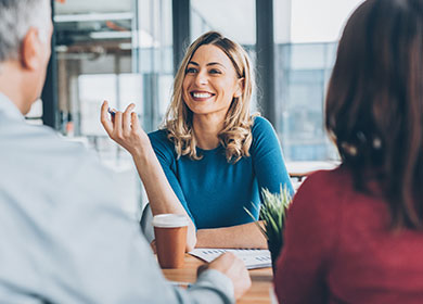 Person sits across from two people smiling.