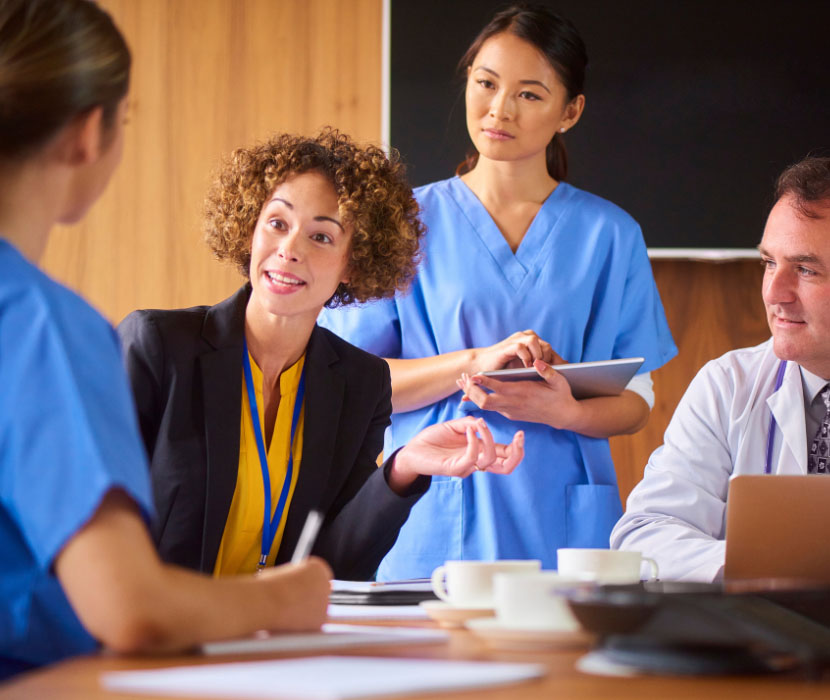Person sits at table in house typing on a laptop.