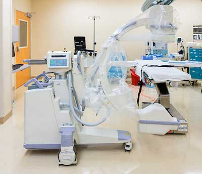 A C arm positioned in an empty operating room