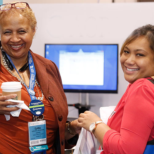 Start-up_500x500 Two women smiling at camera at expo hall.