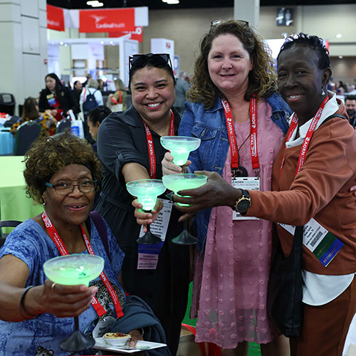 Group of people hold glowing drinks in Expo Hall.