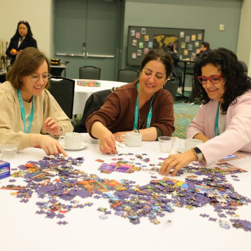 Three women work on a puzzle at Expo