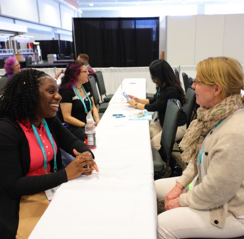 Two women chat at Expo mentor meet up